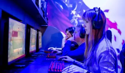 EGX Berlin: People with headphones on desktop computers